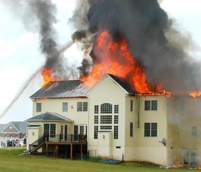Fire engulfed the top of a house and causes severe fire damages while the smoke residue goes up the sky.