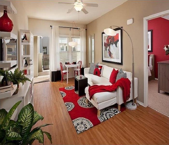 The room has neutral colors everywhere and accent colors of red, black, and white are accessories to blend with the furniture