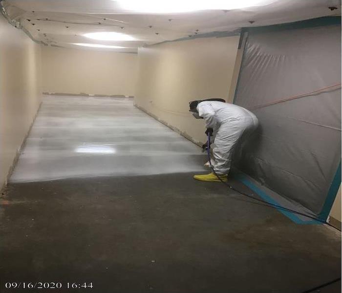 The Technician applies encapsulation compound on the hallway floor during the Mold Remediation service.